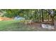 Wooded backyard with a seating area, storage shed, and natural landscaping for a tranquil outdoor experience at 2357 Whitehouse Rd, Dacula, GA 30019