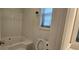 Clean bathroom featuring a bathtub and window, designed for relaxation at 2357 Whitehouse Rd, Dacula, GA 30019