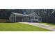 Light blue single-story home featuring a front porch, covered parking, and a manicured lawn at 2357 Whitehouse Rd, Dacula, GA 30019