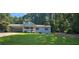 Charming, light blue single-Gathering home with a well-manicured front yard and covered parking area at 2357 Whitehouse Rd, Dacula, GA 30019