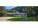 Well-maintained light blue house featuring a covered parking area, front porch, and lush green lawn at 2357 Whitehouse Rd, Dacula, GA 30019