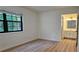 Bright main bedroom featuring hardwood floors and a large window, adjacent to the bathroom at 2357 Whitehouse Rd, Dacula, GA 30019