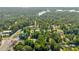 Aerial view showcases the residential homes surrounded by lush greenery with a view of Lake Lanier in the distance at 2560 Fairlane Dr, Cumming, GA 30041