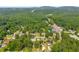 Scenic aerial view of homes surrounded by lush trees in a neighborhood, with a road nearby at 2560 Fairlane Dr, Cumming, GA 30041