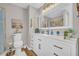 Bright bathroom featuring a large vanity with drawers and cabinets, a commode and a framed mirror at 2560 Fairlane Dr, Cumming, GA 30041