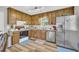 Well-lit kitchen with wood cabinets, stainless steel refrigerator, and modern appliances at 2560 Fairlane Dr, Cumming, GA 30041