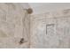 Close up of decorative, tiled walk-in shower showing shower head and a tile inset at 2560 Fairlane Dr, Cumming, GA 30041