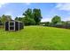 Backyard shed on a lush green lawn and partially enclosed by a wooden fence at 71 Barrington Dr, Hiram, GA 30141