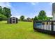 Backyard featuring deck, shed, and lush green lawn under a bright, sunny sky at 71 Barrington Dr, Hiram, GA 30141