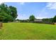 Backyard featuring lush green lawn, mature trees, and a wooden fence for privacy at 71 Barrington Dr, Hiram, GA 30141