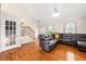 Spacious living room with a comfortable leather sectional, hardwood floors, and natural light, creating an inviting atmosphere at 71 Barrington Dr, Hiram, GA 30141