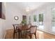 Cozy dining room with hardwood floors, a chandelier, a table with seating for four, and access to the deck at 1402 Mclendon Dr, Decatur, GA 30033