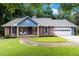 Charming brick home with a well-manicured lawn, inviting front porch, and attached two-car garage at 1402 Mclendon Dr, Decatur, GA 30033