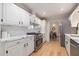 Modern kitchen featuring white cabinets, marble countertops, stainless steel appliances, and hardwood floors at 1402 Mclendon Dr, Decatur, GA 30033