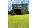 Exterior of house showcasing a spacious backyard with a lush green lawn, deck and manicured landscape at 6398 Foggy Oak Dr, Fairburn, GA 30213