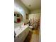 Bright bathroom features a vanity with a sink, toilet, shower and a floral shower curtain at 6398 Foggy Oak Dr, Fairburn, GA 30213