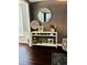 Hallway featuring a decorative console table, ornate decorations, and dark hardwood flooring at 6398 Foggy Oak Dr, Fairburn, GA 30213