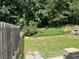 A lush backyard includes a wooden fence, a well-maintained lawn, mature trees, and landscaping at 1570 Jami Hollow Way, Lawrenceville, GA 30043