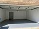 Clean, spacious garage with a gray painted floor and walls; also includes a door to the house at 1570 Jami Hollow Way, Lawrenceville, GA 30043