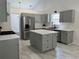 Updated kitchen with gray cabinets, stainless appliances, an island, and stone countertops at 1570 Jami Hollow Way, Lawrenceville, GA 30043