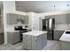 Updated kitchen with gray cabinets, stainless appliances, an island, and stone countertops at 1570 Jami Hollow Way, Lawrenceville, GA 30043