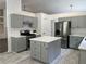 Updated kitchen with gray cabinets, stainless appliances, an island, and stone countertops at 1570 Jami Hollow Way, Lawrenceville, GA 30043