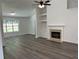 Living room with a fireplace, built-in shelves, and ample natural light creating a cozy atmosphere at 1570 Jami Hollow Way, Lawrenceville, GA 30043