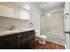 Bathroom featuring dark wood vanity, skylight, and tiled shower with glass door at 174 Village Dr, Hiram, GA 30141