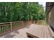 Enjoy outdoor living on this spacious wood deck with railing, bench seating, and wooded views at 174 Village Dr, Hiram, GA 30141