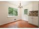 Bright dining area with hardwood floors, chandelier, large window, and white door and cabinets at 174 Village Dr, Hiram, GA 30141