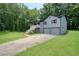 Two-story home with a two-car garage and a charming front porch, surrounded by green grass and trees at 174 Village Dr, Hiram, GA 30141