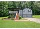 Charming two-story home with gray siding, a front porch, and a two-car garage nestled among lush trees at 174 Village Dr, Hiram, GA 30141