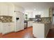 Updated kitchen featuring white cabinets, stainless steel appliances, tile backsplash and hardwood floors at 174 Village Dr, Hiram, GA 30141