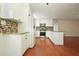 Open kitchen area featuring white cabinets, stainless steel appliances, hardwood floors, and granite countertops at 174 Village Dr, Hiram, GA 30141