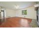 Bright living room with hardwood floors, neutral walls, a stone fireplace, and an open layout to the kitchen at 174 Village Dr, Hiram, GA 30141