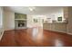 Spacious living room with hardwood floors, a stone fireplace, and an open floor plan leading to the kitchen at 174 Village Dr, Hiram, GA 30141