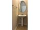 Powder room with pedestal sink, oval mirror, and tile flooring at 3457 Dacite Ct, South Fulton, GA 30349