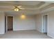 Neutral bedroom featuring carpet, a tray ceiling, ceiling fan, and paneled doors at 3457 Dacite Ct, South Fulton, GA 30349