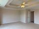 Carpeted bedroom with tray ceiling, ceiling fan, and neutral paint at 3457 Dacite Ct, South Fulton, GA 30349
