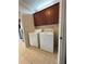 Functional laundry area with washer, dryer, and overhead dark wood cabinets for storage at 3457 Dacite Ct, South Fulton, GA 30349