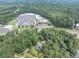 Aerial view of a home and wooded lot near retail and roads with ample parking at 8035 Rockbridge Rd, Lithonia, GA 30058