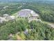 Aerial view of a home and wooded lot near retail and roads with ample parking at 8035 Rockbridge Rd, Lithonia, GA 30058