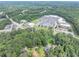 Aerial view of a home and wooded lot near retail and roads with ample parking at 8035 Rockbridge Rd, Lithonia, GA 30058