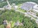 Aerial view of a home and wooded lot near retail and roads with ample parking at 8035 Rockbridge Rd, Lithonia, GA 30058