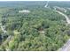 An aerial view shows the lot surrounded by mature trees and nearby highway access at 8035 Rockbridge Rd, Lithonia, GA 30058