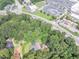 Aerial view of a home and wooded lot near retail and roads with ample parking at 8035 Rockbridge Rd, Lithonia, GA 30058
