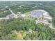 Aerial view of a home and wooded lot near retail and roads with ample parking at 8035 Rockbridge Rd, Lithonia, GA 30058