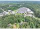 Aerial view of a home and wooded lot near retail and roads with ample parking at 8035 Rockbridge Rd, Lithonia, GA 30058