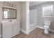 Bathroom with gray vanity and mirror and shower with a tub at 8035 Rockbridge Rd, Lithonia, GA 30058