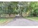 Driveway entrance through wooded area with a wooden fence at 8035 Rockbridge Rd, Lithonia, GA 30058